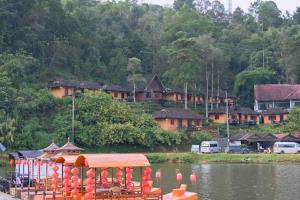 a boat with a pavilion in the middle of a lake at ยูนานรักไทย รีสอร์ต in Ban Pang Mo