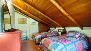 Un dormitorio con dos camas y techo de madera. en Casa Nazari, en Benaocaz