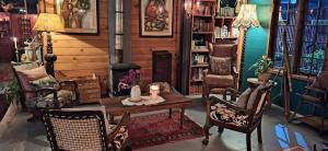 a living room with a table and chairs and a fireplace at ECO Lodge Villa Villekula in The Crags