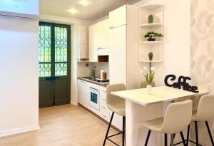 a kitchen with white cabinets and a table and chairs at Casa Telli - da Merilù in Turin