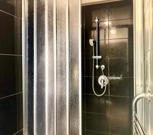 a shower with a hose on a tiled wall at Casa Telli - da Merilù in Turin +11 photos