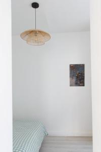 a bedroom with a bed and a pendant light at appartement entre plages et centre historique in Concarneau