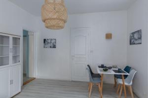 a white dining room with a table and chairs at appartement entre plages et centre historique in Concarneau +28 photos