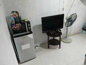 a room with a television and a small refrigerator at Zac's Lodging Bocaue in Bocaue