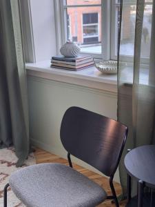 una silla negra sentada frente a una ventana en Upscale 3BR Apartment in City Center, en Copenhague