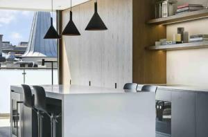 a kitchen with a white counter and some chairs at Elite Penthouse prime location in Copenhagen