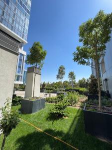 two trees in a garden in front of a building at Nest One Downtown View, Элитные апартаменты с панорамным видом на город 210 in Tashkent