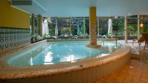 ein großes Schwimmbad in einem Gebäude in der Unterkunft Calimbra Wellness Hotel Superior in Miskolctapolca