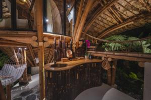 Una habitación con techo de madera y un lavabo. en Green Earth Bali Bamboo villas, en Sidemen