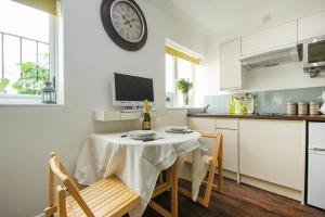 a kitchen with a table and a clock on the wall at Between Piers - Central- by Brighton Holiday Lets in Brighton & Hove