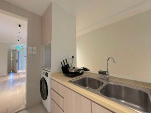 a kitchen with a sink and a washing machine at The Keystone Clarke Quay in Singapore