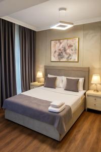 - une chambre avec un grand lit, 2 tables de nuit et 2 lampes dans l'établissement Parliament Hotel Baku, à Baku