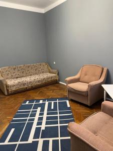 a living room with two chairs and a couch and a rug at GREENMIST apartaments in Kyiv