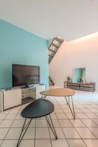 sala de estar con 2 mesas y TV en Le Central, en Thonon-les-Bains