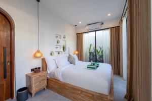 a bedroom with a large white bed and a window at Lavilaya Villa in Kerobokan +49 photos