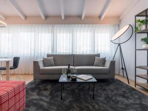 a living room with a couch and a table at Chiaroscuro By Case al Lago in Brescia