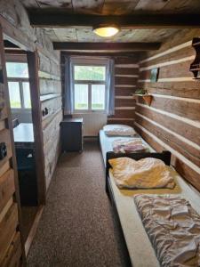 a room with two beds in a log cabin at Chata Roubenka in Sedloňov