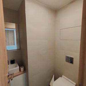 a bathroom with a toilet and a sink at Sky Park 26th floor free parking free Wi-Fi in Bratislava