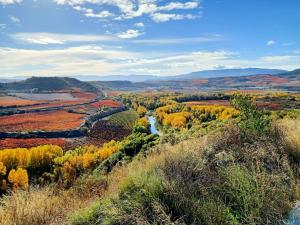 a view of a valley with a river and fall foliage at El Refugio in Fuenmayor