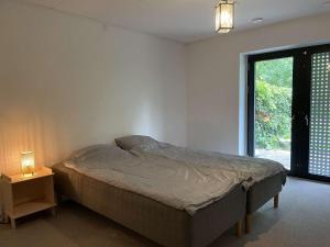 コペンハーゲンにあるCopenhagen Finestのベッドとテーブルの上にランプが置かれた寝室