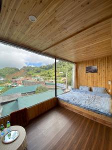 a bedroom with a bed and a large window at A Phủ Home's Tà Xùa in Bắc Yên