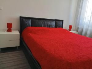a bedroom with a red bed with two red lamps at Appartamento Guido in Monfalcone