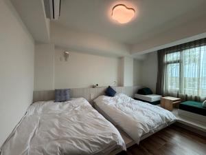 a bedroom with a large bed and a window at Xunfeng B&B in Gukeng