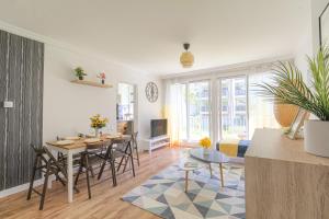a living room with a table and a dining room at Lumineux et cosy proche Eurexpo & Groupama Stadium in Bron