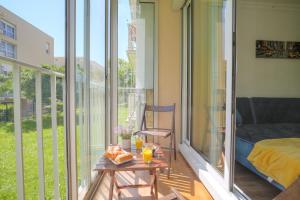 a room with a balcony with a bed and a table at Lumineux et cosy proche Eurexpo & Groupama Stadium in Bron