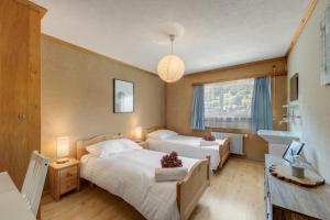 a hotel room with two beds and a sink at Hébergement l'Escale - Le Châble - Verbier in Le Châble