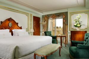 a bedroom with a bed and a chair and a table at Parco dei Principi Grand Hotel & SPA in Rome