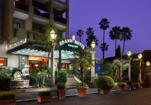 a hotel with palm trees in front of a building at Parco dei Principi Grand Hotel & SPA in Rome