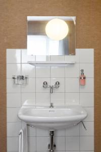 a white bathroom with a sink and a mirror at Hébergement l'Escale - Le Châble - Verbier in Le Châble
