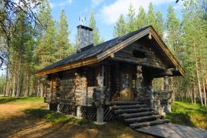 a log cabin in the woods with a chimney at Norcota- Blockhaus mit Auroraskylight in Inari