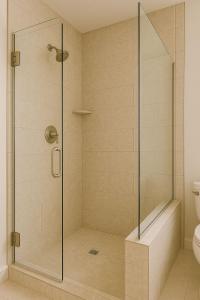 une douche avec une porte vitrée dans une salle de bain dans l'établissement Solkom Homestay, à Bố Trạch