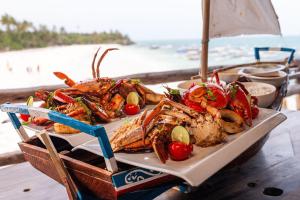 a tray of seafood on a table next to the beach at SeVi Boutique Hotel in Matemwe +126 photos