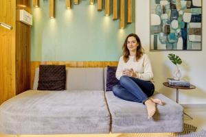 a woman sitting on top of a bed at FabExpress Sumit Palace in Mumbai