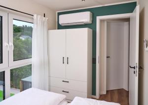 a bedroom with a white cabinet and a window at Luxuscontainer am Nürburgring #1 in Adenau