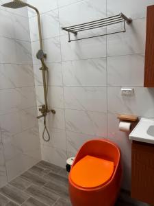 an orange seat in a bathroom with a shower at Xunfeng B&B in Gukeng +10 photos