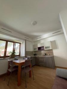 a kitchen with a table and chairs in a room at Apartmány Obora v Podbezdězí in Doksy