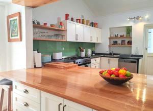 a kitchen with a bowl of fruit on a wooden counter at Lake Retreat Stay in Marina da Gama