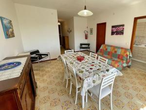 a living room with a table and a couch at Spacious apartment near the beach in Porto Santa Margherita di Caorle +13 photos