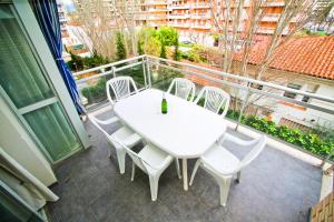 een witte tafel en stoelen op een balkon bij Apartamento ROURA in La Pineda