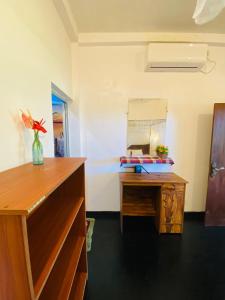 a room with a desk and a mirror at Sasaa Guest House in Mirissa