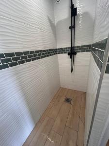 a shower room with white and black tiles at Appartement cozy et spacieux in Amiens