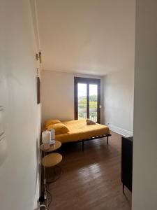 a bedroom with a bed with a yellow blanket at Appartement cozy et spacieux in Amiens