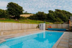 a swimming pool in a yard next to a fence at 4 Bed in Lobb oc-s33517 in Georgeham