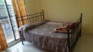 - une chambre avec un lit avec un cadre métallique et une fenêtre dans l'établissement Top in Town, à Hapugastalawa