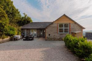 a stone house with a patio in front of it at 4 Bed in Lobb oc-s33517 in Georgeham