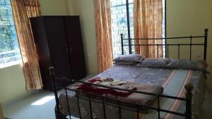 - une chambre avec un lit avec un cadre métallique dans l'établissement Top in Town, à Hapugastalawa